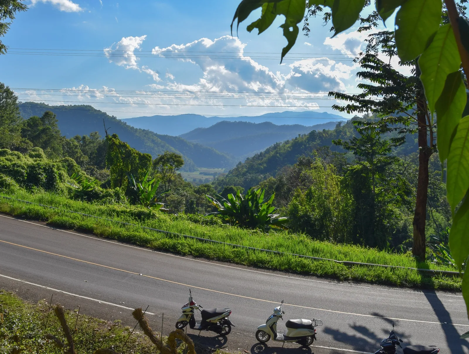 Motorbikes parked along a mountain road overlooking forested hills near Chiang Mai, Thailand. Motorbikes parked along a mountain road overlooking forested hills near Chiang Mai, Thailand.