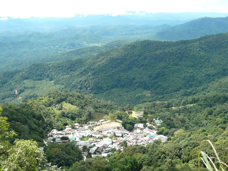A small hill tribe village nestles in a green valley surrounded by forested mountains near Chiang Mai. A small hill tribe village nestles in a green valley surrounded by forested mountains near Chiang Mai.